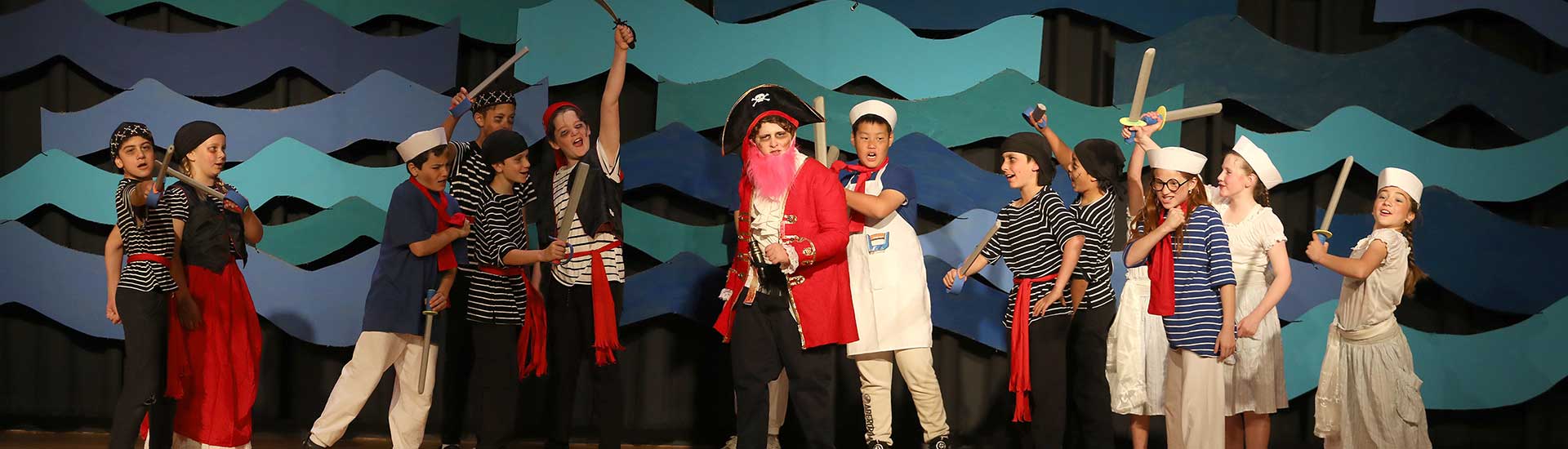 Pirates and other characters on stage during the fifth grade play