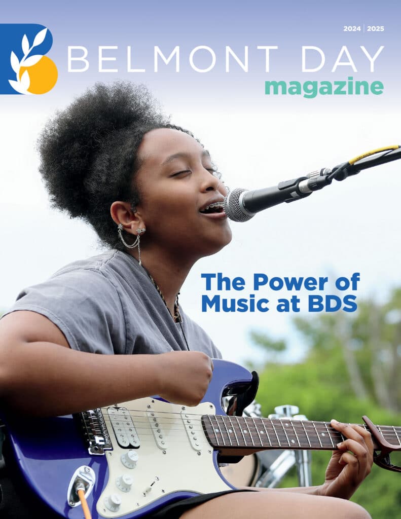 A student sings and plays the electric guitar