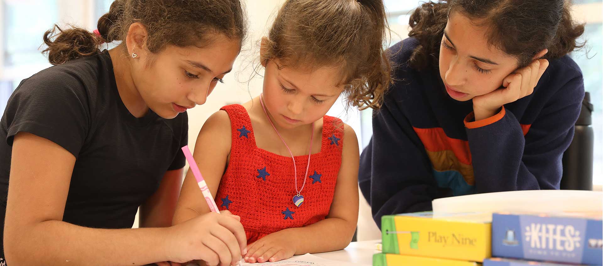 Three girls work together on a cross-graded partner activity